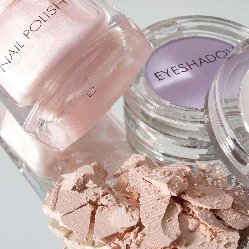 Pink nail varnish and purple eyeshadow cosmetics imagery